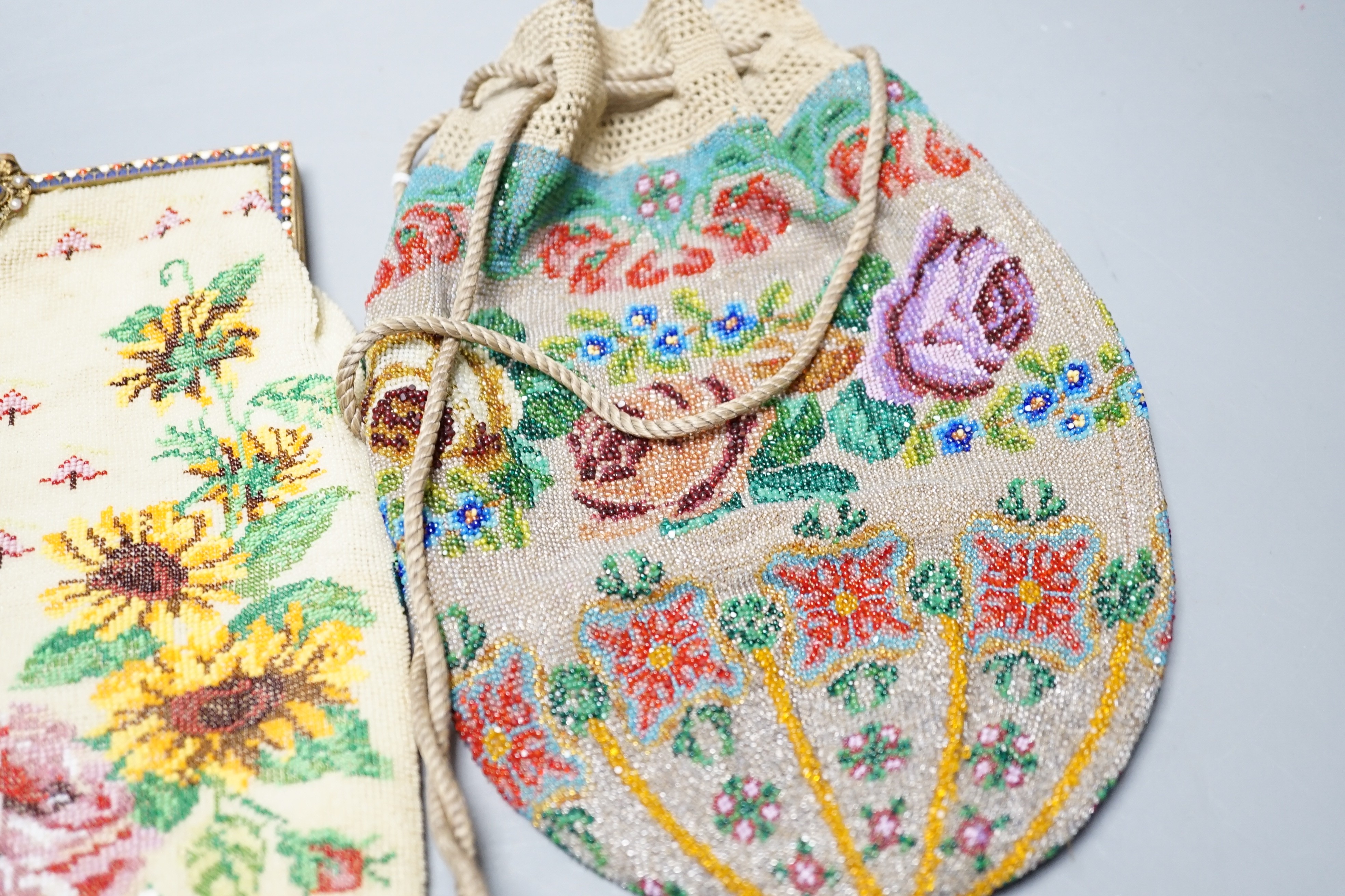 A 19th century framed beaded bag, designed with roses and garden flowers and another similar floral beaded drawstring bag, framed bead bag 21.5 cms high including clasp